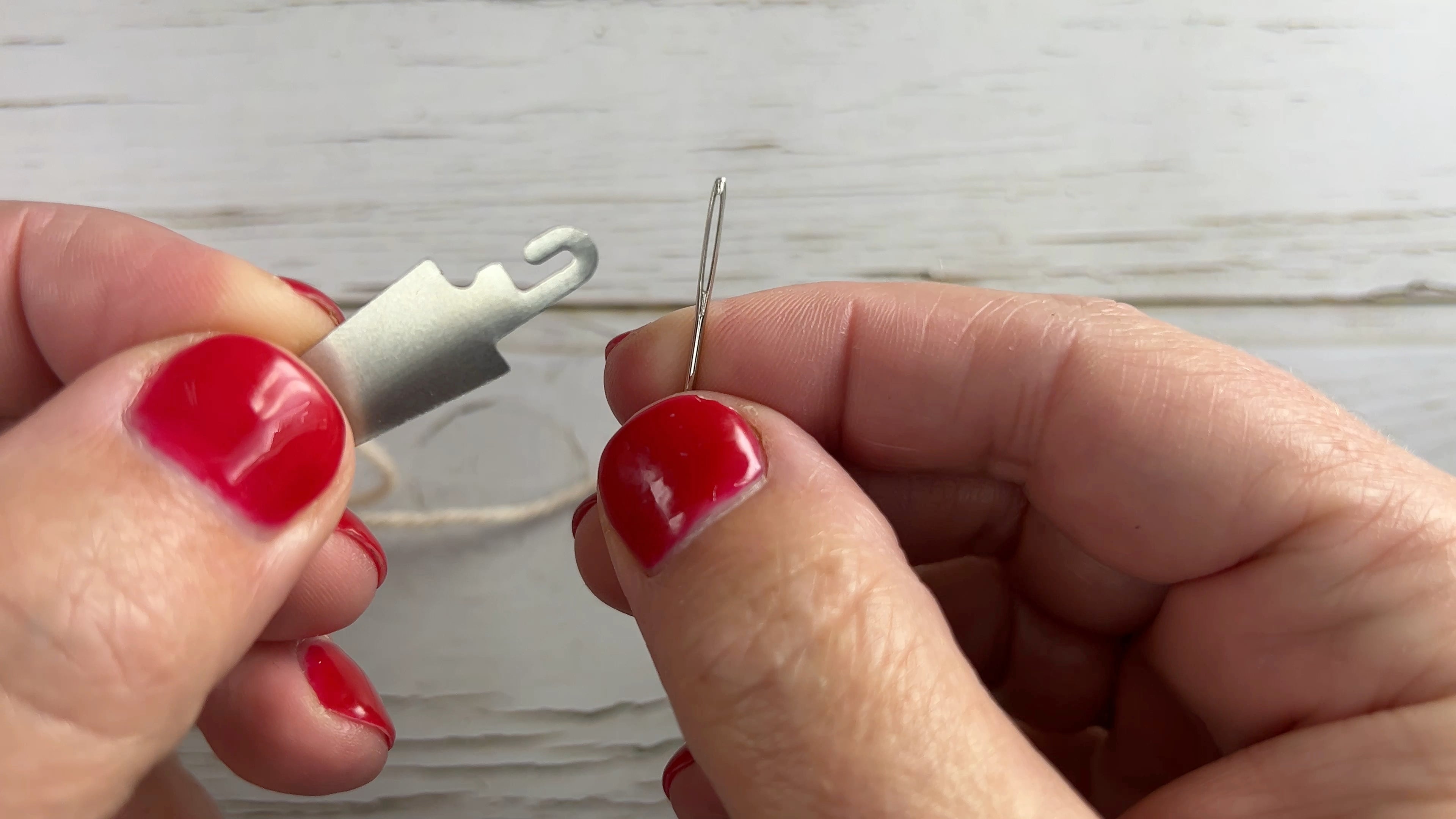 Load video: A 46 second video showing how to thread a tapestry needle using a yarn threader by Sew Sew Mellow